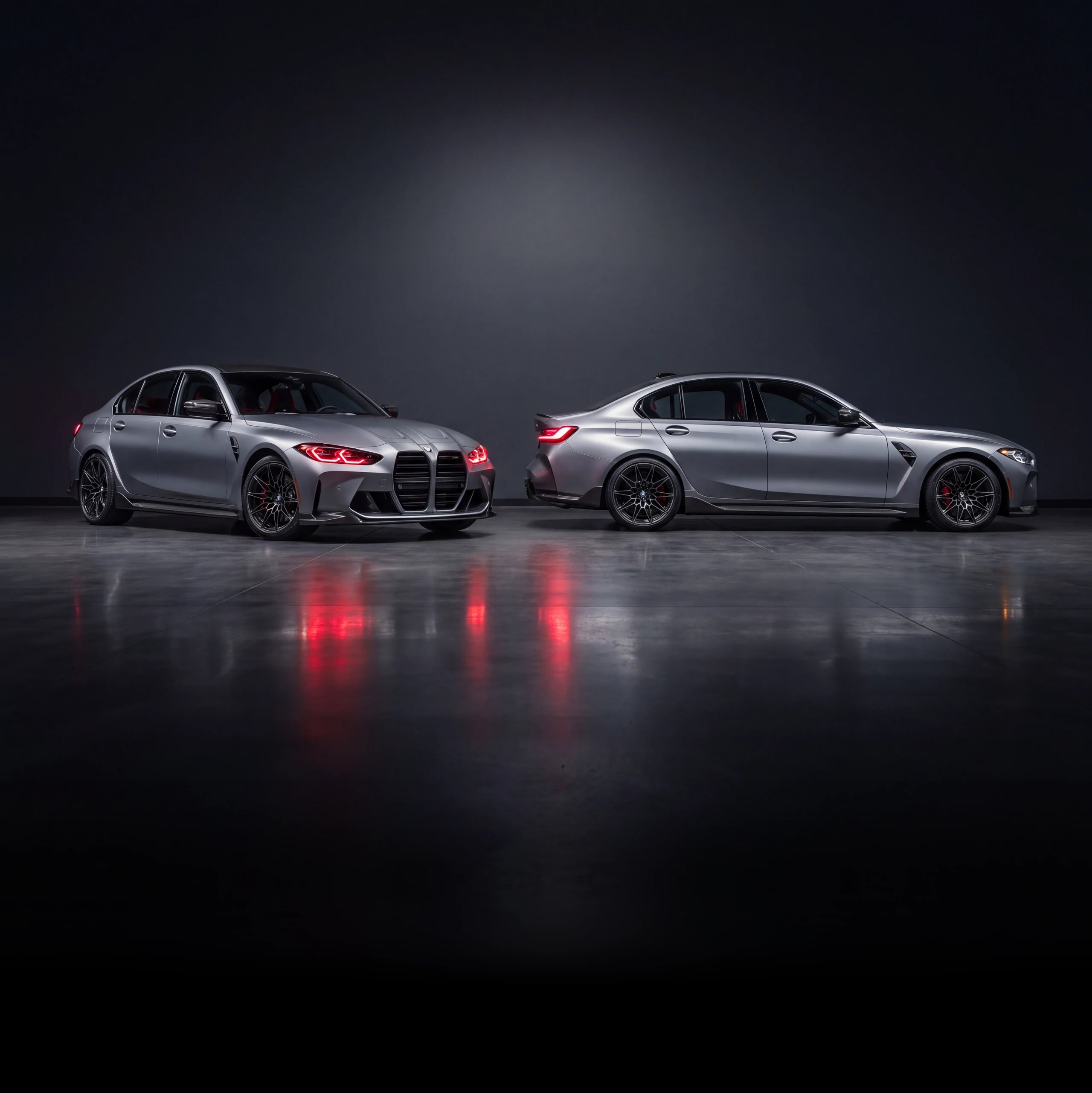 Two BMW M3s protected with VOIR clear paint protection film in a dark studio